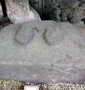 A large rectangular stone block from Yazılıkaya with two rounded protuberances on top, resting on gravel.