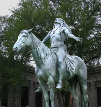 Appeal to the Great Spirit bronze sculpture of a bare-chested man seated on a horse with his arms raised upward.