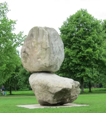 Rock on Top of Another Rock with a large boulder balanced on another stone in a park.