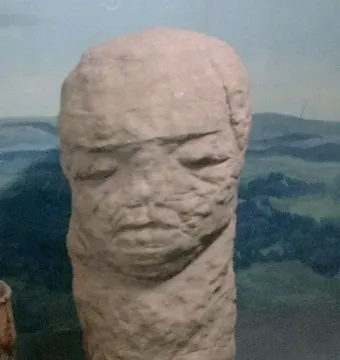 Škloŭ Idol, a weathered stone sculpture with a stylized human-like face.