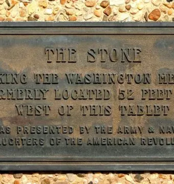 Bronze Jefferson Pier plaque with raised lettering mounted on a pebble-dash stone wall.