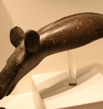 Alunda Moose carved stone sculpture shown on a clear stand