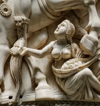 Barberini Ivory relief showing a bare-chested female figure holding up a basket beneath a horse’s legs and an armored human leg.