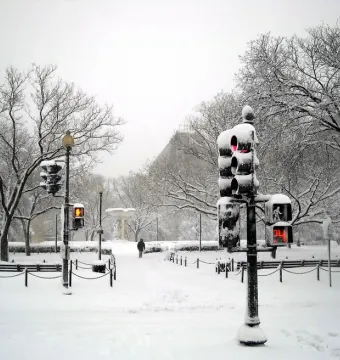Dupont Circle Fountain in a snow-covered plaza with bare trees and traffic lights nearby