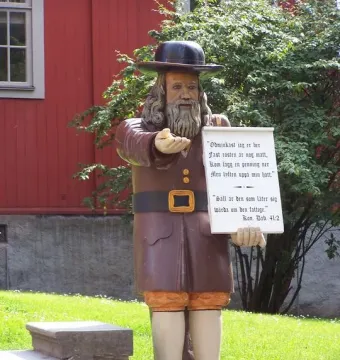 Rosenbom, a life-size wooden figure of a bearded man in historical clothing, holding out one hand and a scroll.