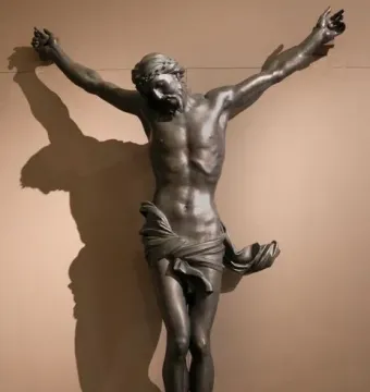 Bernini\'s Corpus, a dark bronze crucified Christ with outstretched arms, bowed head, and crown of thorns.