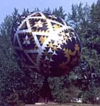 Vegreville Pysanka sculpture with geometric silver, gold, and dark patterns on a pedestal.