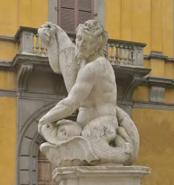 Dolphin Fountain with a bearded Triton sculpture on a pillar above a carved face spout.