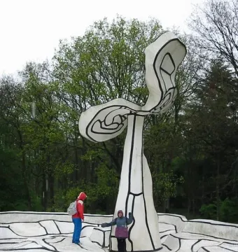 Jardin d\'émail by Jean Dubuffet, showing a white curving sculpture with black outlines and two people standing on the undulating surface.