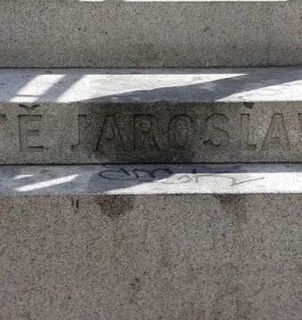 Close-up of the stone base of the Jaroslav Hašek monument with carved lettering.