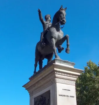 Marqués del Duero equestrian statue of a man on a rearing horse atop a stone pedestal.