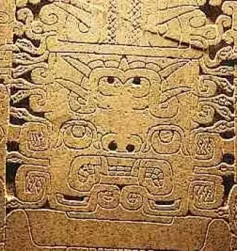 Close-up of the Raimondi Stela showing a stylized face with swirling symmetrical carved patterns.