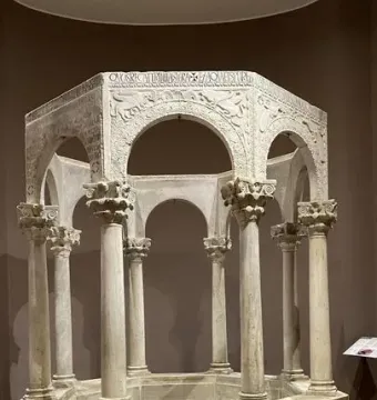 Baptistry of Callistus, an octagonal stone baptismal font with carved arches, columns, and decorative reliefs.