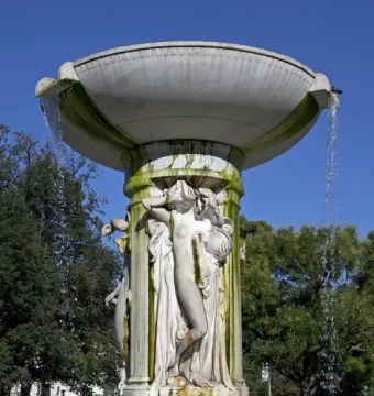 Dupont Circle Fountain with cascading water, classical figures carved on the central shaft, and green-stained marble.