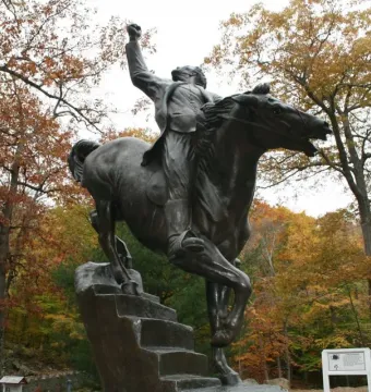 Israel Putnam equestrian statue on a sculpted base surrounded by autumn trees