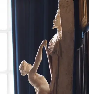 La Gloire, a nude figure pulling forcefully at a tall block that reveals a bearded man\'s profile.