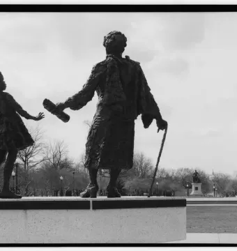 Rear view of the Mary McLeod Bethune Memorial bronze statue with the Emancipation Statue and Capitol dome in the background.