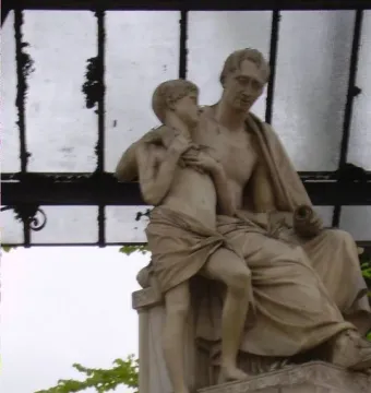 Monument to Nicola Demidoff showing a seated older figure holding a standing child beneath a glass and metal roof.