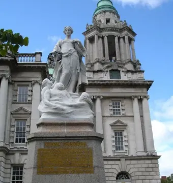 Titanic Memorial statue in Belfast, with a female figure holding a wreath above figures on a granite pedestal.