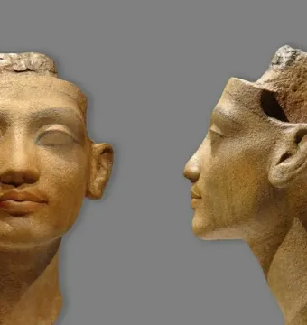 Unfinished Head of Nefertiti shown from the front and in profile, with delicate carved features and a rough, incomplete top.