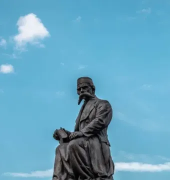 Vuk Karadžić Monument showing a bronze seated figure holding an open book on a stone pedestal.