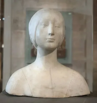 Pale marble bust of a young woman wearing a close-fitting headpiece