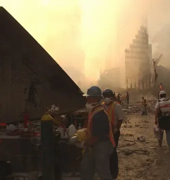 Cloud Fortress stands at the left amid rubble, with recovery workers in hard hats and reflective vests in the foreground.