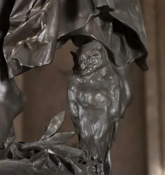 Close-up of the Gloria Victis bronze sculpture showing an owl perched on a leafy branch beneath draped forms.
