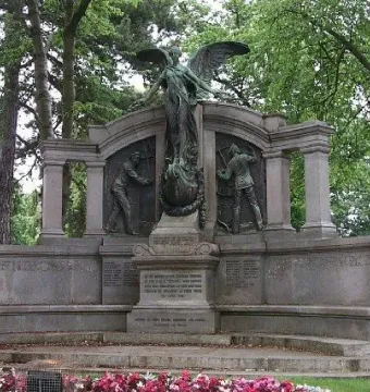 Titanic Engineers\' Memorial with a winged bronze figure and relief panels in a park.