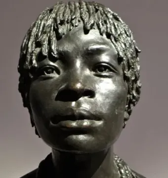 Bronze bust of Woman of Central Africa with short textured hair and layered beaded necklaces on a dark base.