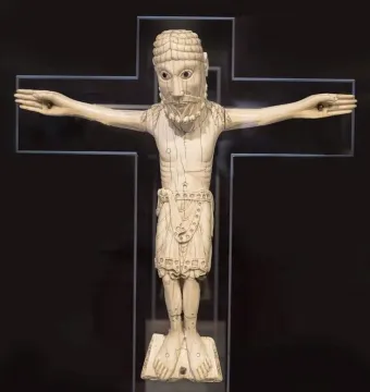Carrizo Christ carved ivory figure with outstretched arms on a dark cross-shaped background