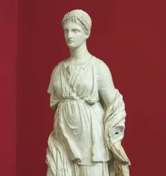 Artemis Diadoumena marble statue with braided hair and draped garments, missing the lower arms.