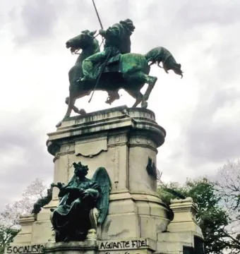 Monument to Giuseppe Garibaldi with a mounted statue atop a graffiti-covered stone pedestal in Buenos Aires.