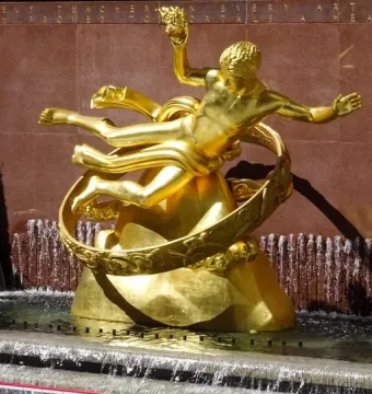 Prometheus, a golden statue in a fountain with water cascading around its base