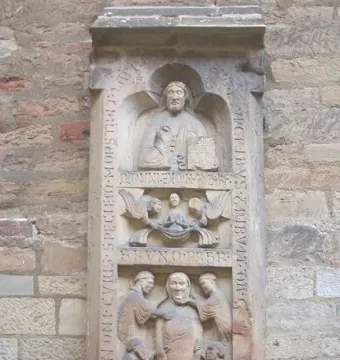 Tomb of Bruno the Priest stone relief with carved figures, angels, and inscriptions on a wall