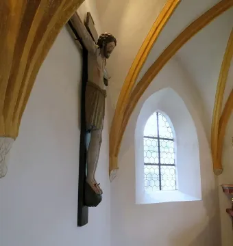 Enghausen Cross wooden crucifix on a white church wall beneath golden arches