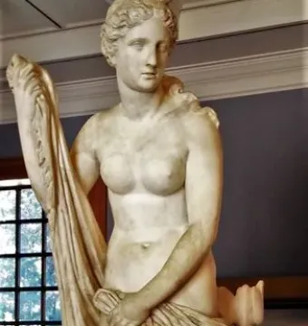 Mazarin Venus, a carved stone statue of a standing female figure holding draped cloth, with a dolphin-like creature at her feet.