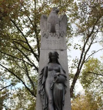 Mutter Kinzig monument with a spread-winged eagle atop a stone pedestal and a bronze female figure below.
