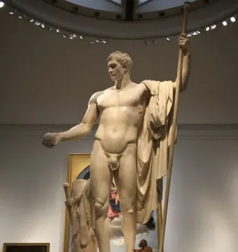 Napoleon as Mars the Peacemaker statue of a muscular male figure holding an orb and staff in a museum