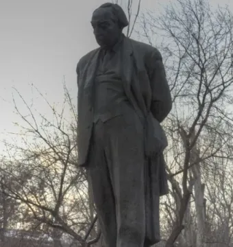 Monument to Avetik Isahakyan, a dark gray statue of a man in a suit on a stone pedestal