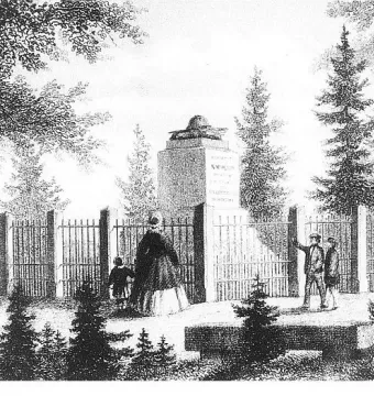 Napoleonstein stone pillar topped with a bicorne hat, enclosed by a fence and surrounded by trees, with several people standing nearby.