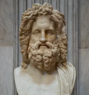 Zeus of Otricoli marble bust with curly hair and a beard on an inscribed pedestal.