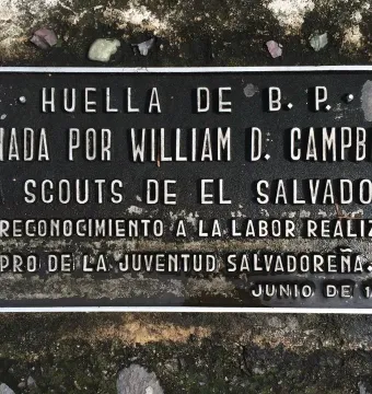 Rectangular plaque for B-P’s footprint with raised Spanish lettering, set into rough dark ground.