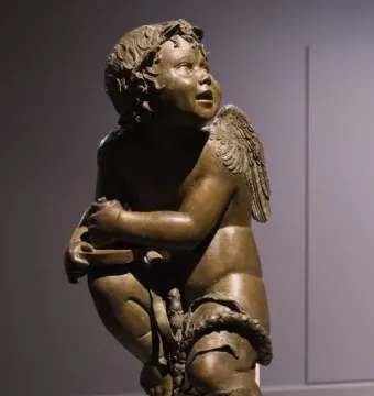 Bronze candelabra angel, a kneeling winged cherub holding a small dish and garland.