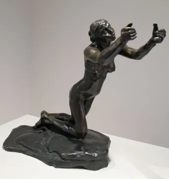 The Implorer bronze sculpture of a kneeling nude woman with her arms raised and palms open.