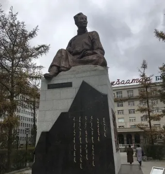 Natsagdorj Monument showing a seated bronze figure on a tiered stone pedestal with inscriptions.