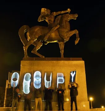 The Bowman equestrian statue atop a pedestal at night, with \