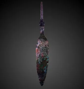 Spear of Lugal with a leaf-shaped metal blade, engraved animal motif, and perforated tang on a dark background.