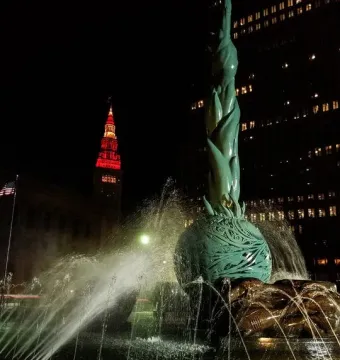 Fountain of Eternal Life lit at night with water jets spraying around the sculpture.