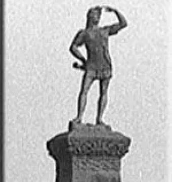 Leif Erikson statue standing on a decorated pedestal with one hand shading his eyes and the other on his hip.